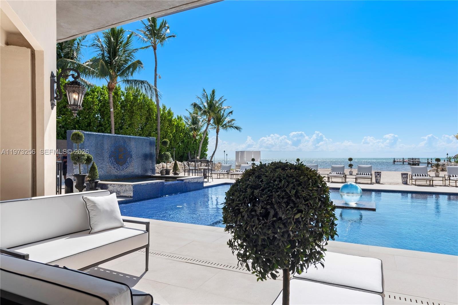 Resort-style mosaic pool with ocean backdrop