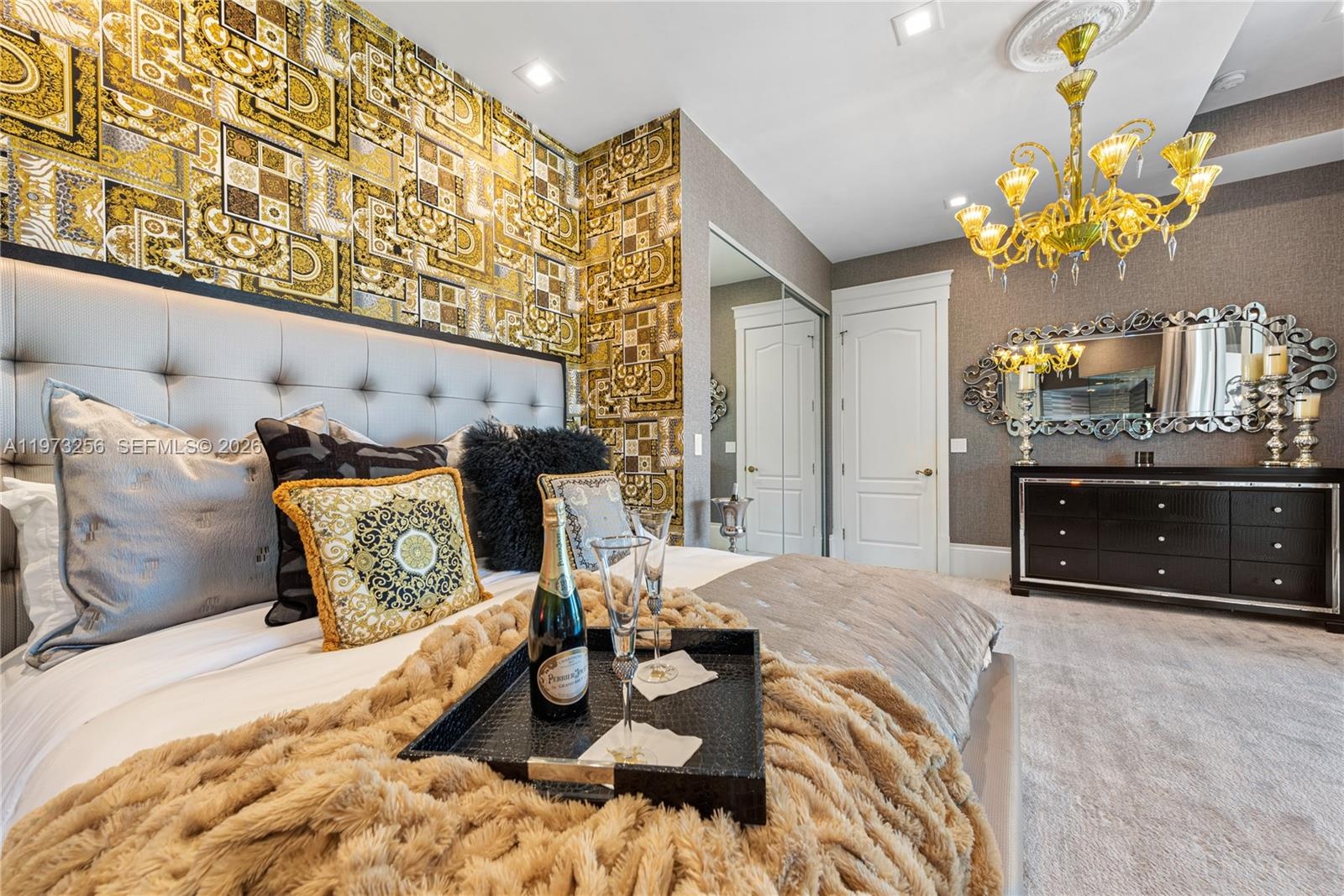 Opulent bedroom with tufted headboard and chandelier